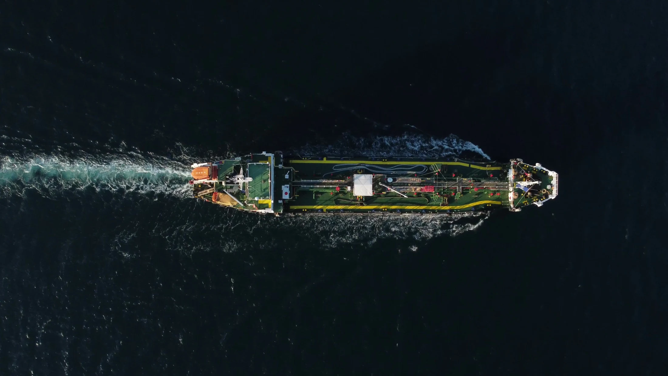 Aerial view of a ship moving across the open sea